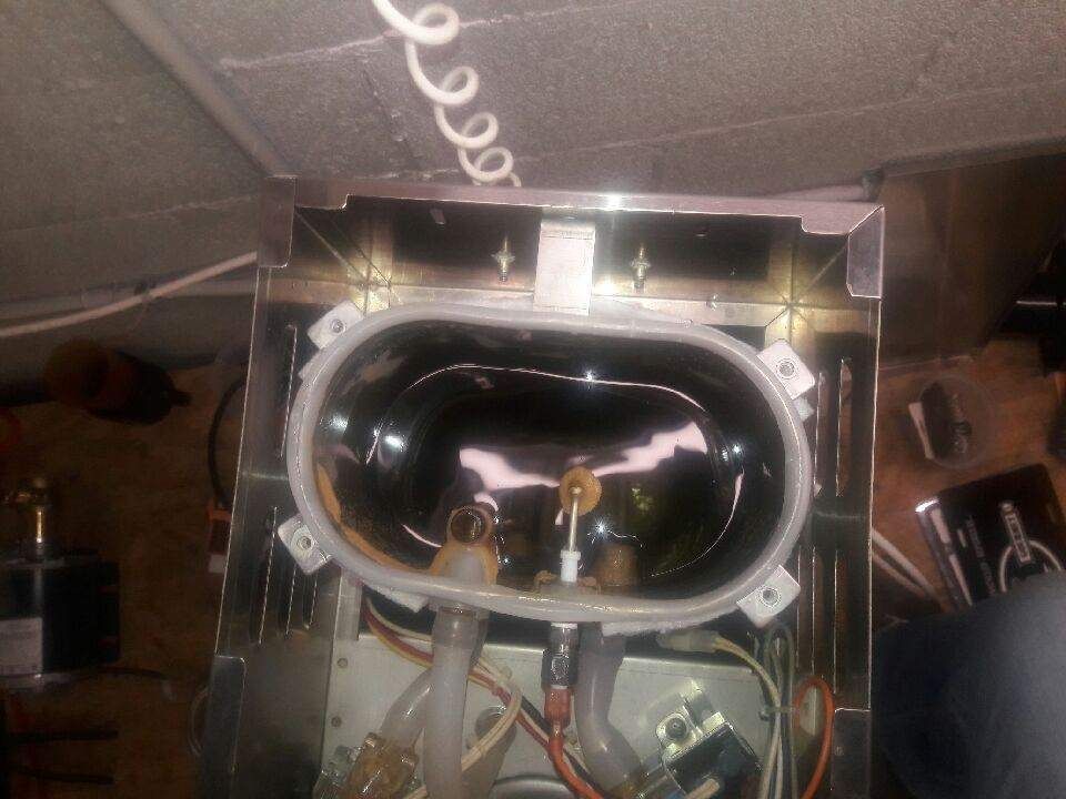 Close-up of a ceiling-mounted black oval speaker or device with exposed wires and metal frame