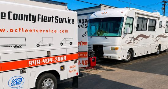 Two County Fleet Service trucks parked side by side, white with orange stripes and logos.