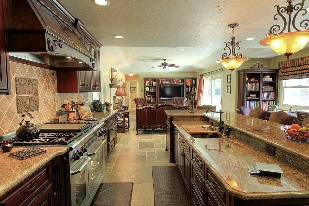 Modern kitchen with granite countertops, stainless appliances, island, and warm pendant lighting