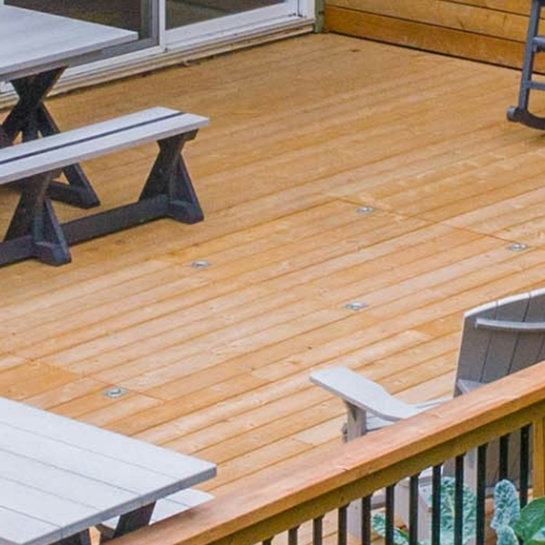 Wooden deck with picnic tables and benches beside a sliding glass door