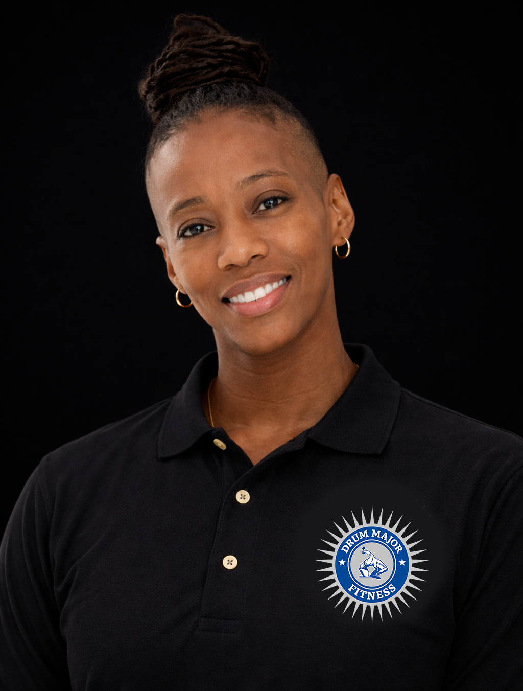A person with hair in a bun wears a black polo shirt featuring a circular