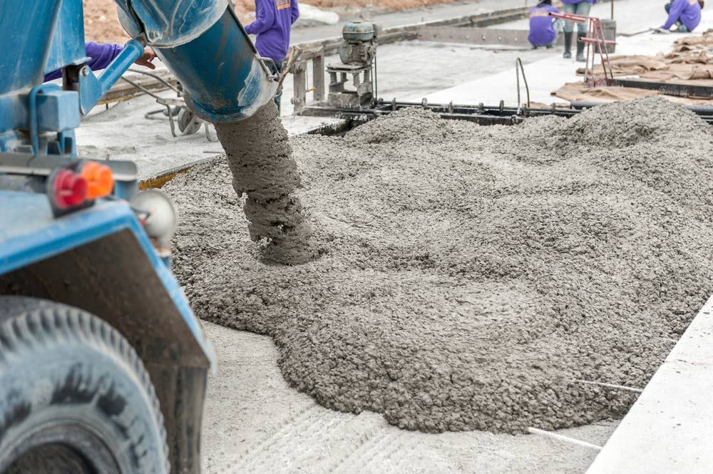A Concrete Truck is Pouring Concrete on a Construction Site — Dampier Street Landscape Supplies in Taminda, NSW