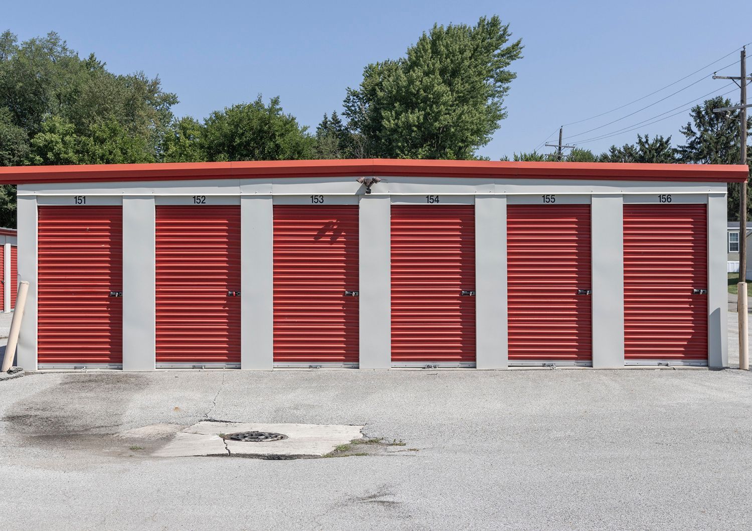 Storage units with red doors and gray walls under a red roof. Storage units with red doors and gray walls under a red roof.