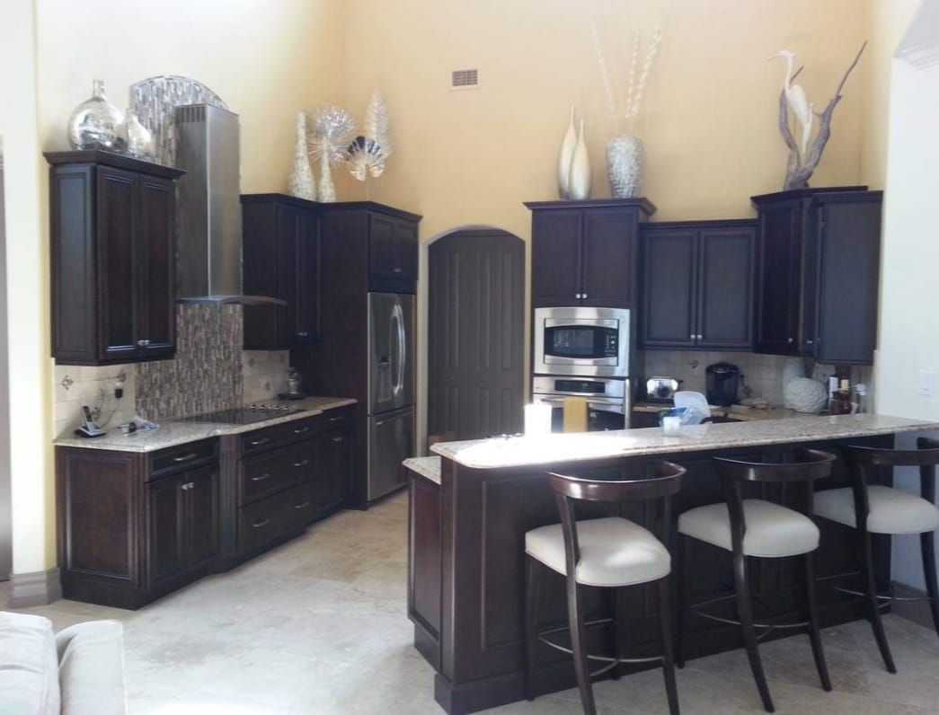 A kitchen with dark cabinets and stainless steel appliances