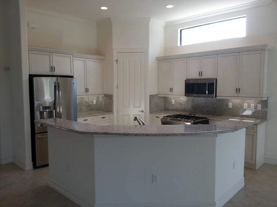 A kitchen with white cabinets and stainless steel appliances.