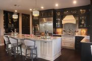 A kitchen with a large island in the middle and stools.