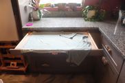 A drawer in a kitchen with a towel on top of it.