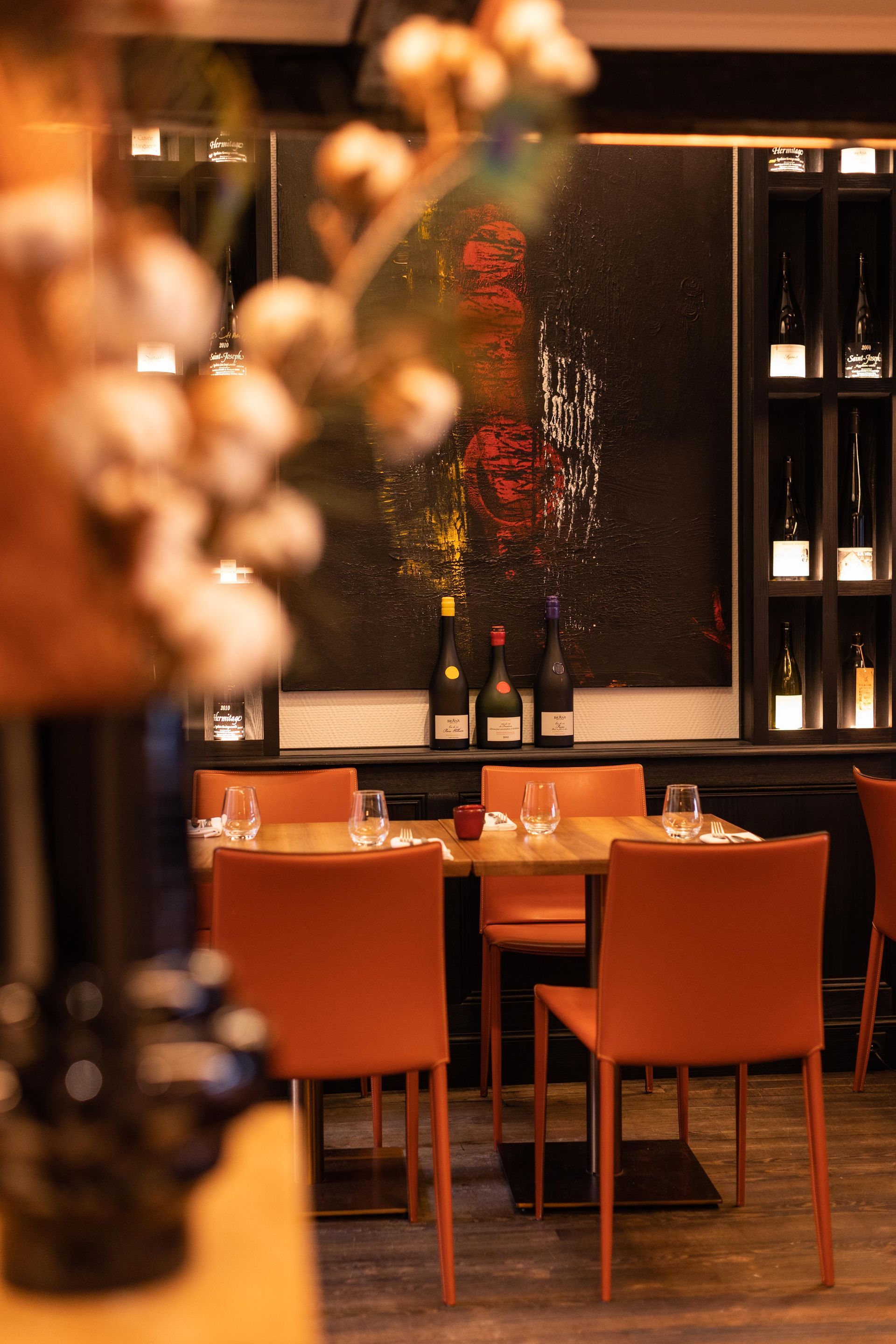 Un restaurant avec des tables et des chaises et un tableau sur le mur.