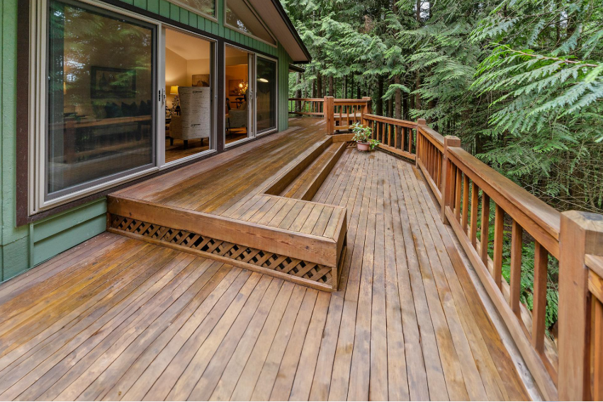 Finished custom wood deck with long railings beside home after Deck Building Services in Buckeye, AZ for outdoor living.