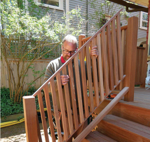 Worker repairs wooden deck stairs and railing during Deck Building Services in Buckeye, AZ to improve safer home access.