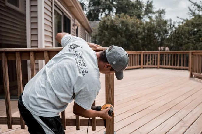 Worker repairs worn deck boards beside a house during Deck Building Services in Buckeye, AZ for a safer outdoor surface.