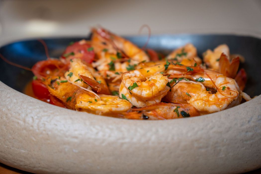 Piatto di rigatoni con salsa di pomodoro su un tavolo grigio.