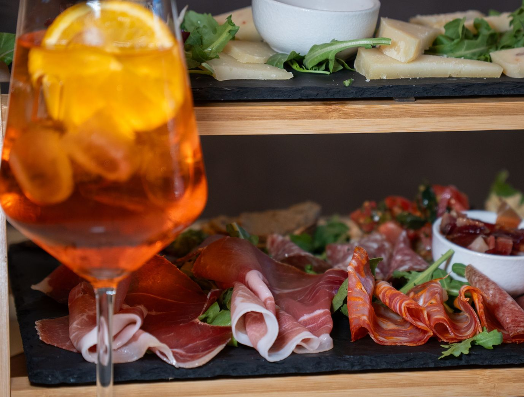 Bottiglie di vetro di liquore ambrato con etichette su un bancone di legno in un bar o in una distilleria