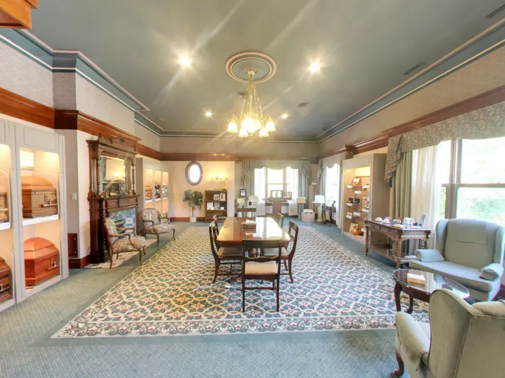 Elegant hotel lobby with patterned carpet, chandelier, seating areas, and large windows