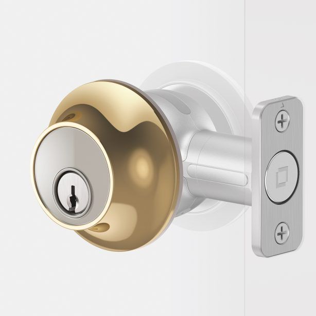 Gold-and-silver door lock with keyhole on a white door knob set against a white background
