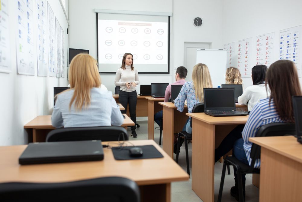 Classroom with students seated at desks facing a teacher and projected presentation screen