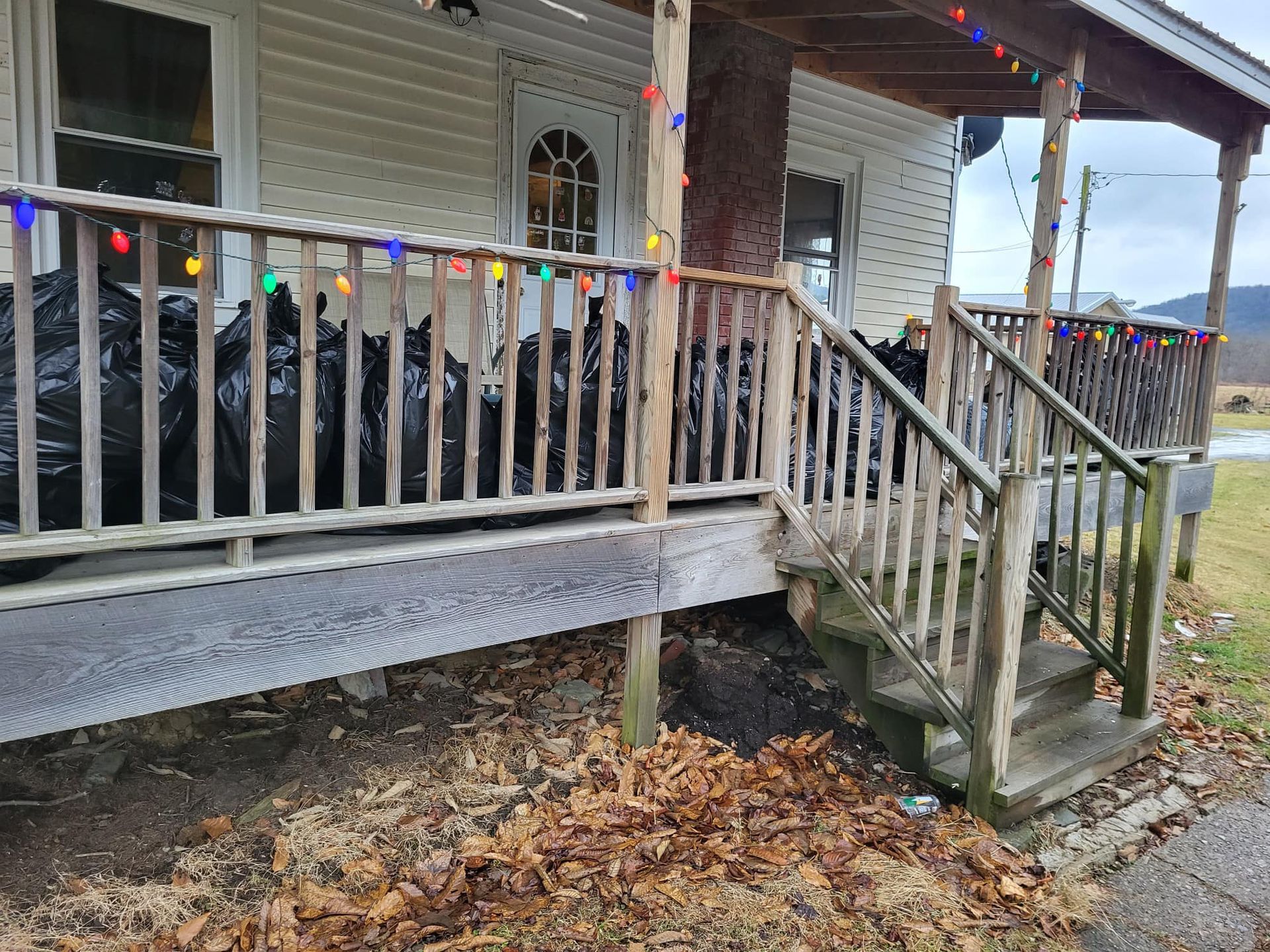 A house with a porch and stairs decorated with christmas lights.