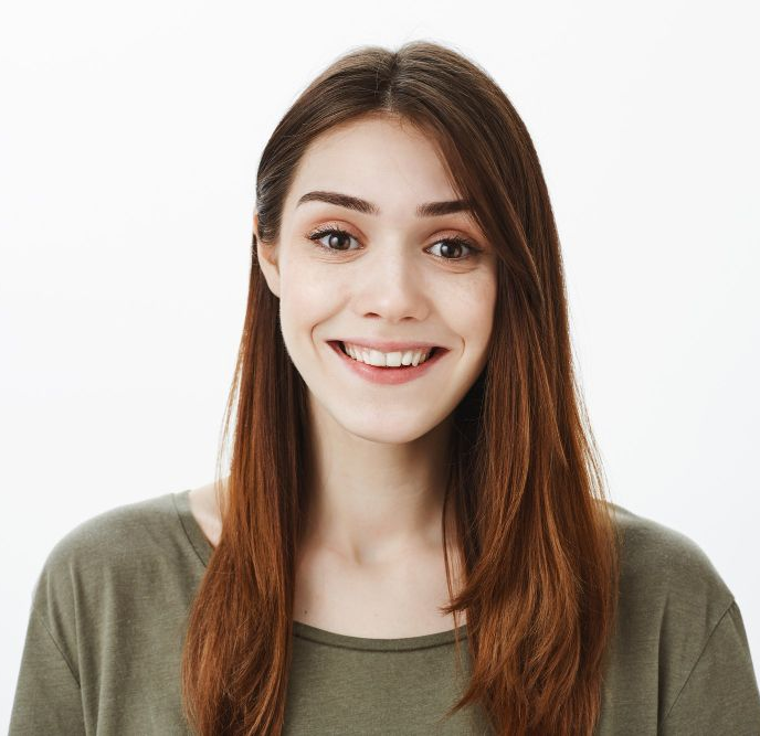 Smiling woman with long brown hair wearing an olive green shirt on a white background