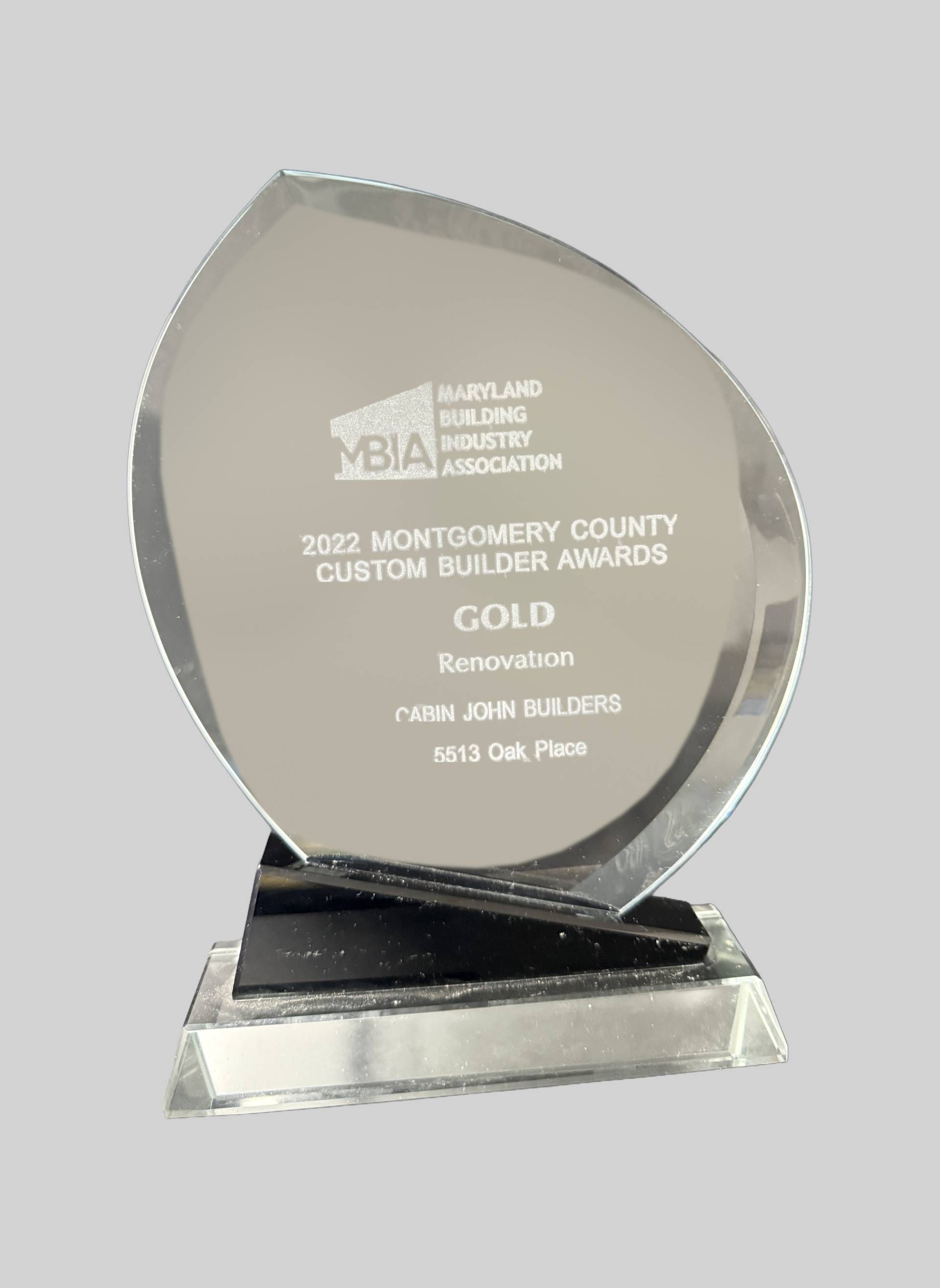 Silver award plaque on a black base with engraved text and a leaf-shaped top.