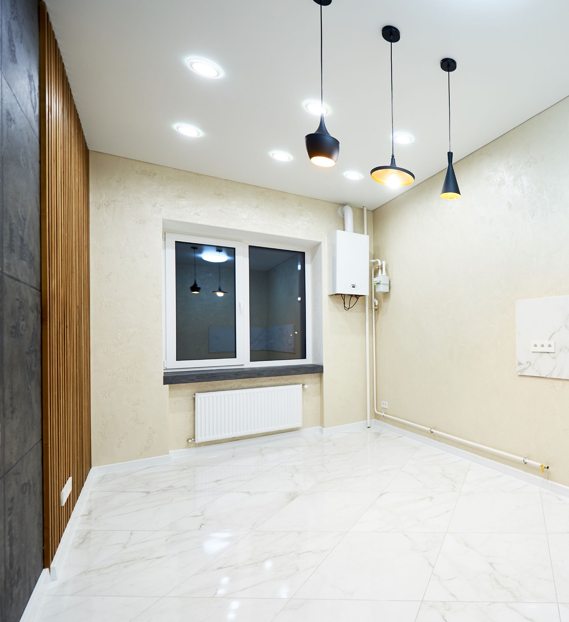 Empty modern room with white tile floor, cream walls, a window, and pendant lights hanging from the ceiling
