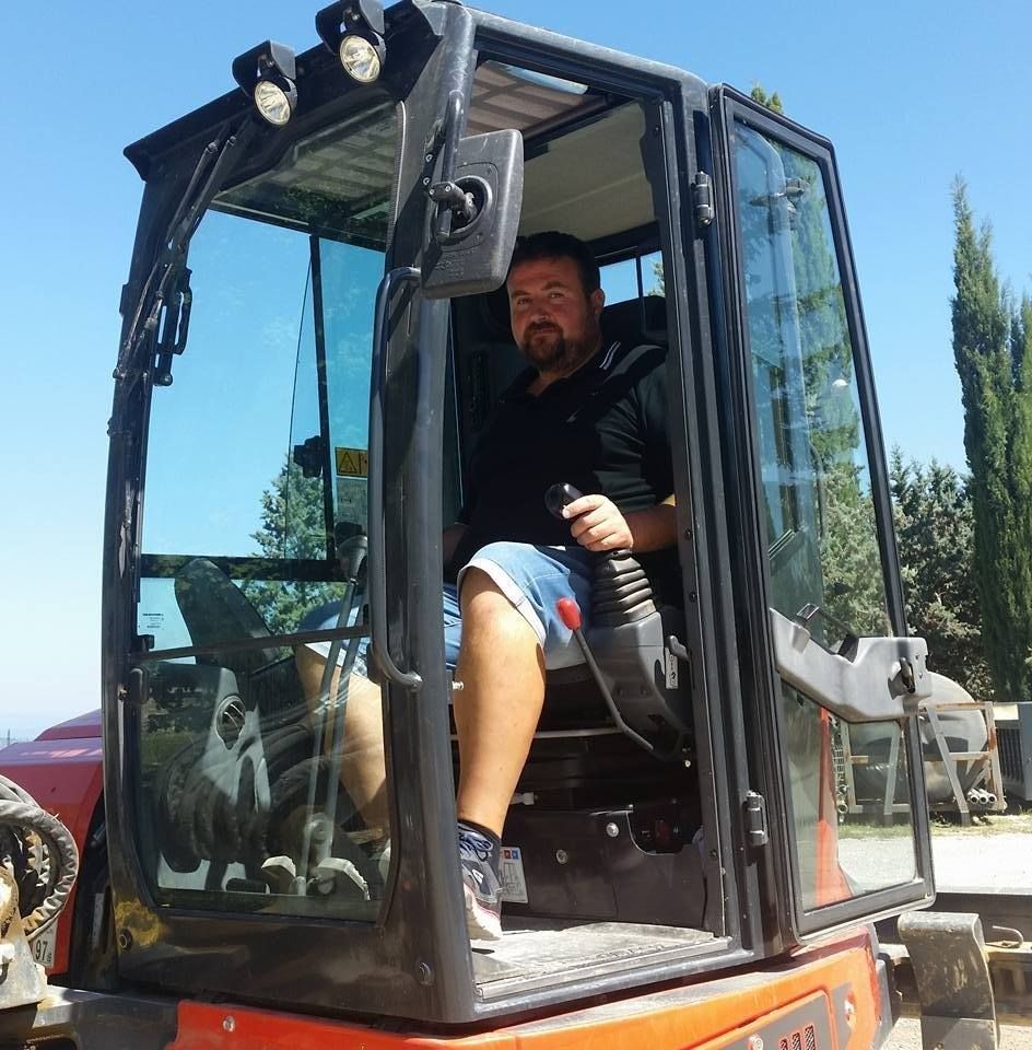 Un uomo è seduto al posto di guida di un veicolo da costruzione