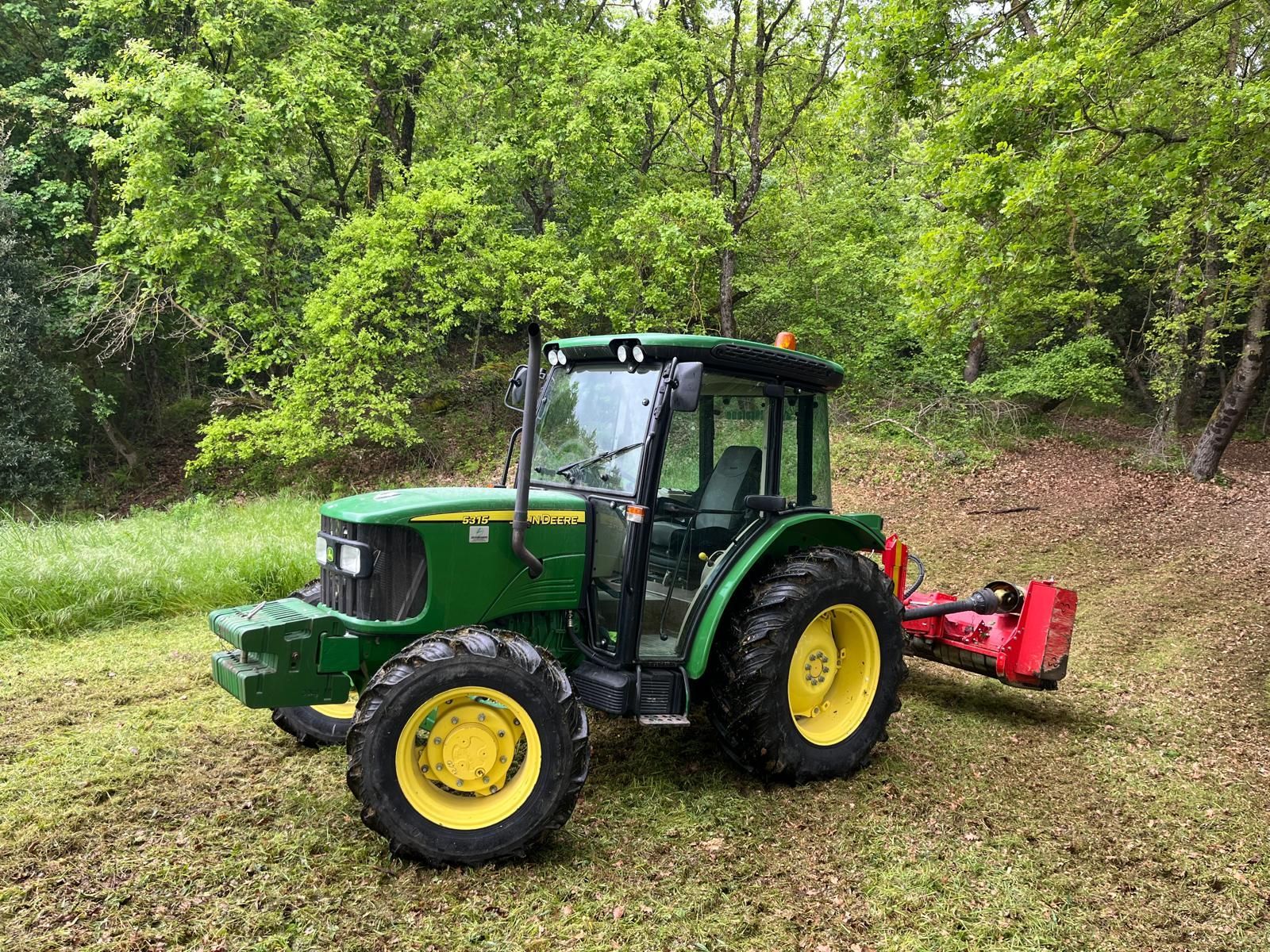 Un trattore verde John Deere è parcheggiato in un campo erboso.