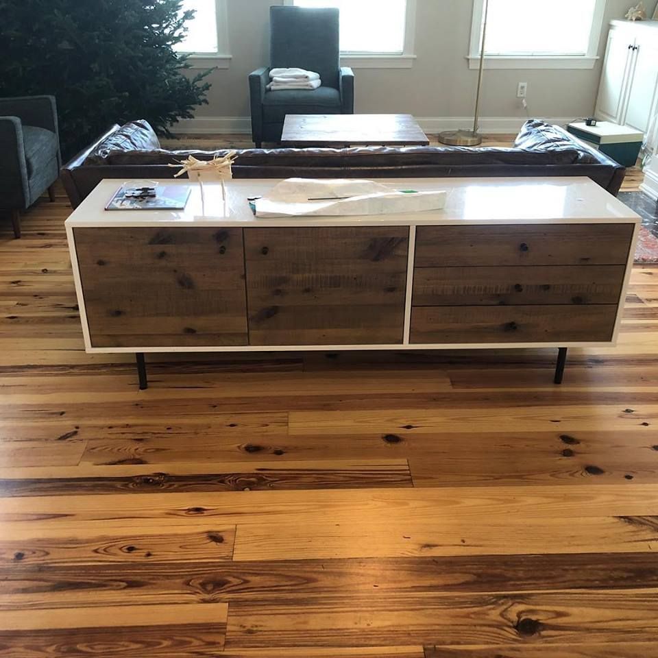 Modern living room with a wooden coffee table, hardwood floor, and chair by bright windows.
