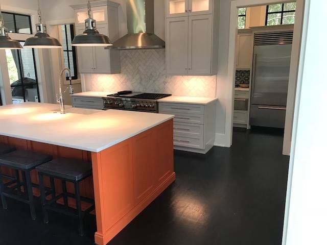 Modern kitchen with white cabinets, stainless steel appliances, and a large island with stools