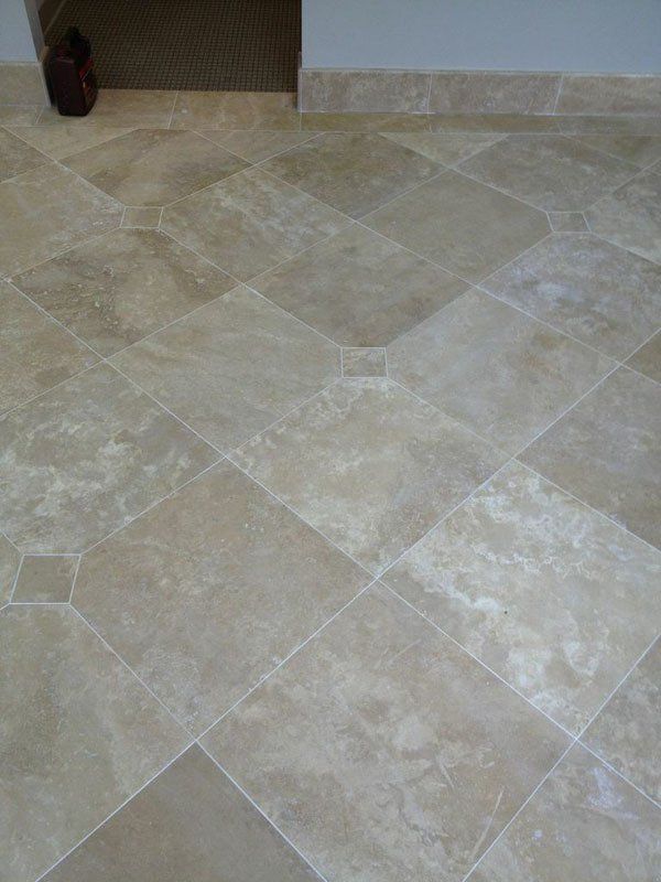 Beige tiled floor with diagonal square pattern and a small dark object in the corner.