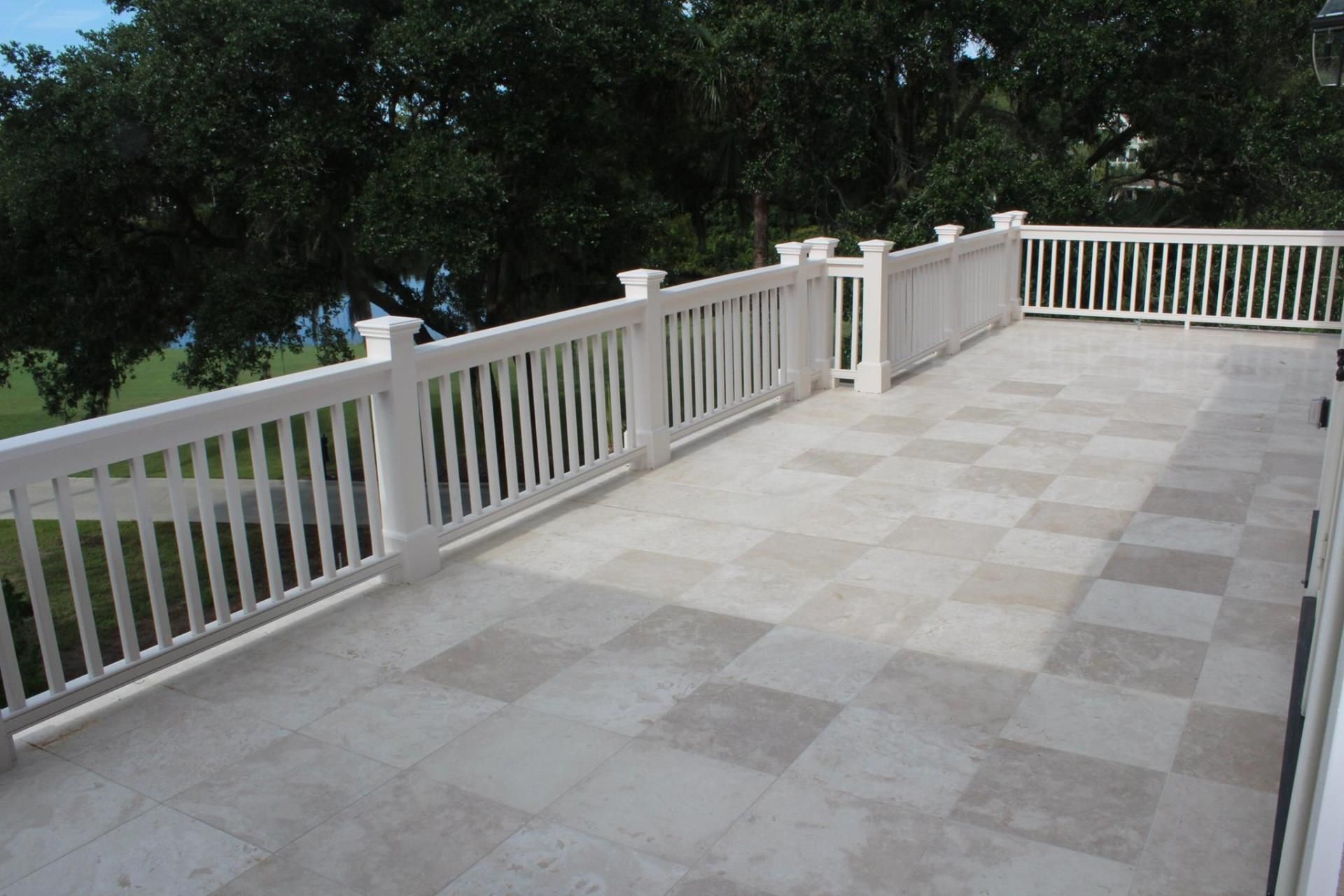 White-railed stone patio or deck overlooking trees and greenery