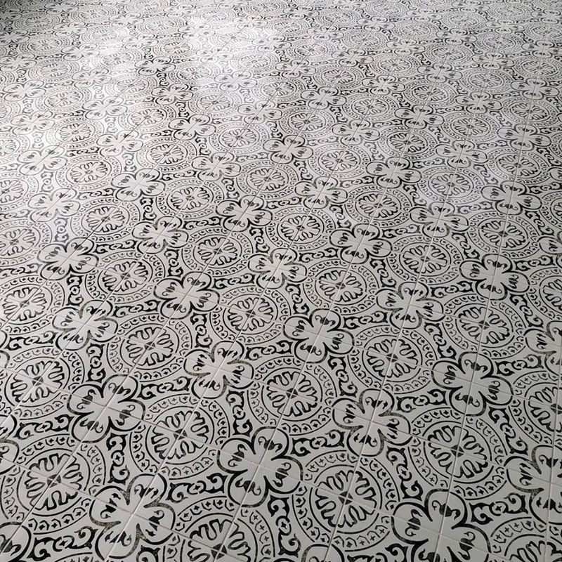 Black-and-white floral patterned fabric or tile surface, viewed from above