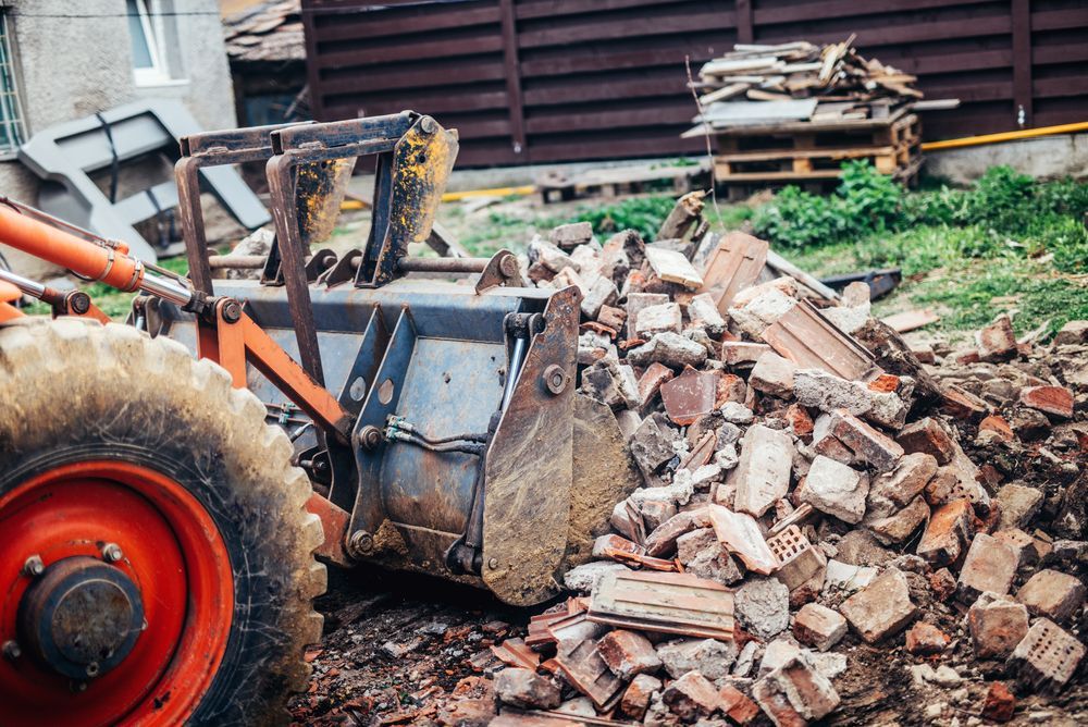 A Bulldozer is Carrying a Pile of Bricks on a Construction Site — Demco In Tweed Shire, NSW