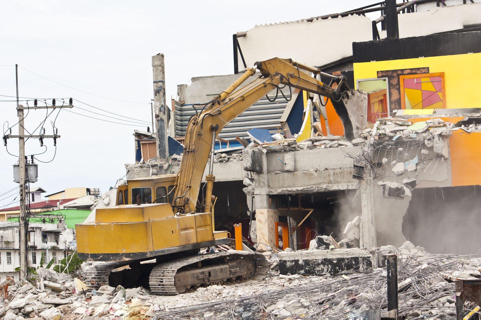 A Large Yellow Excavator is Demolishing a Building — Demco In Currumbin Waters, QLD