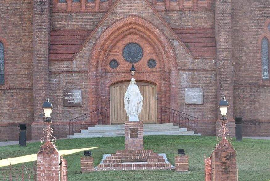 A Statue of Mary is in Front of a Brick Church — Demco In Lismore, NSW 2480