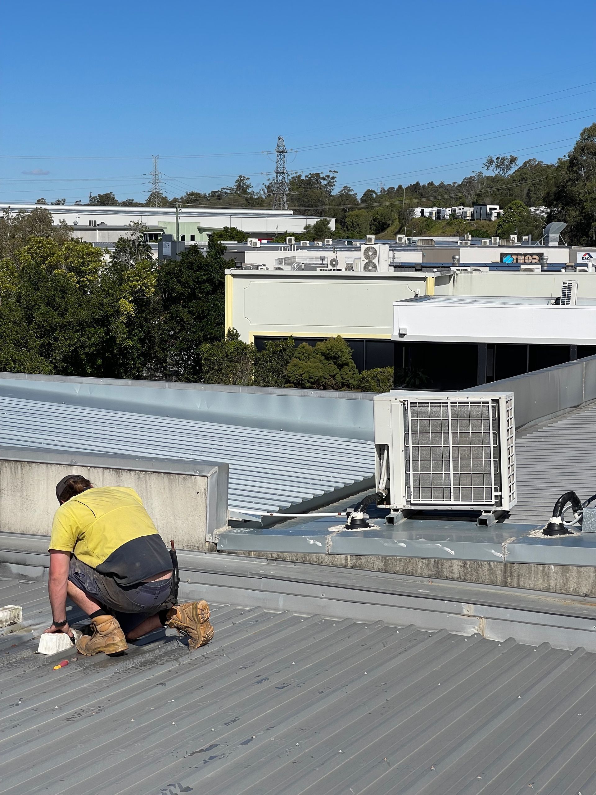 A man is working on the roof of a building. — Demco In Currumbin Waters, QLD