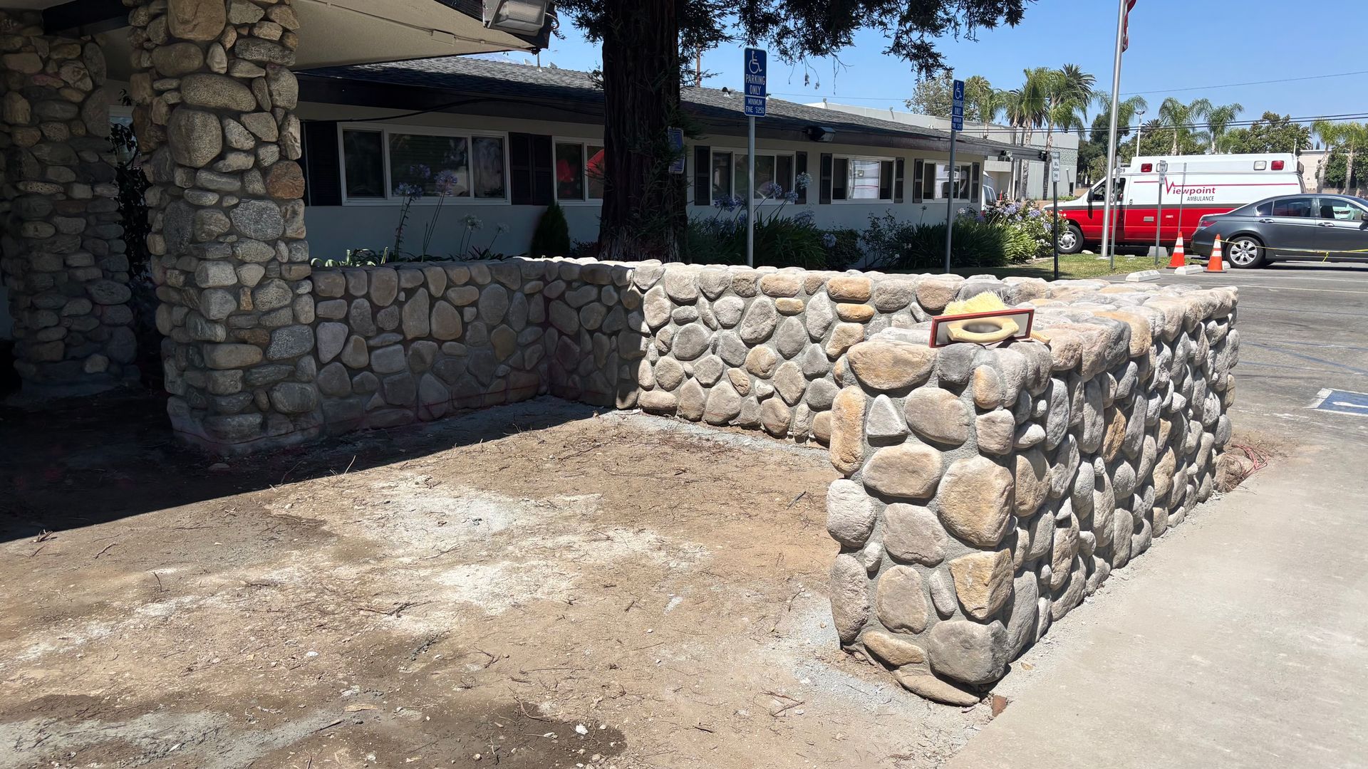 Concrete subgrade preparation with stone veneer block wall installation in Claremont California