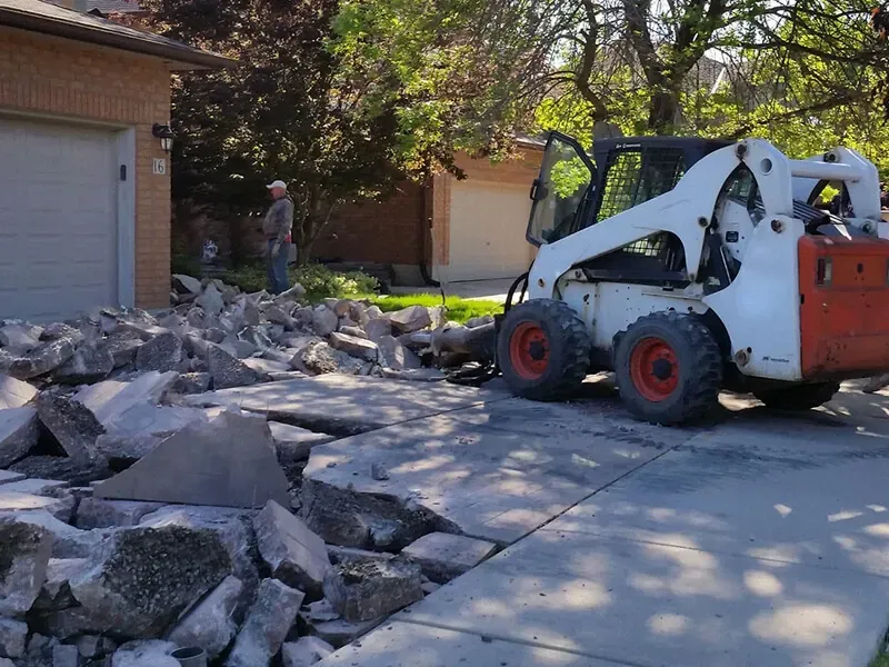 Concrete driveway and sidewalk demolition with Bobcat in Rialto California