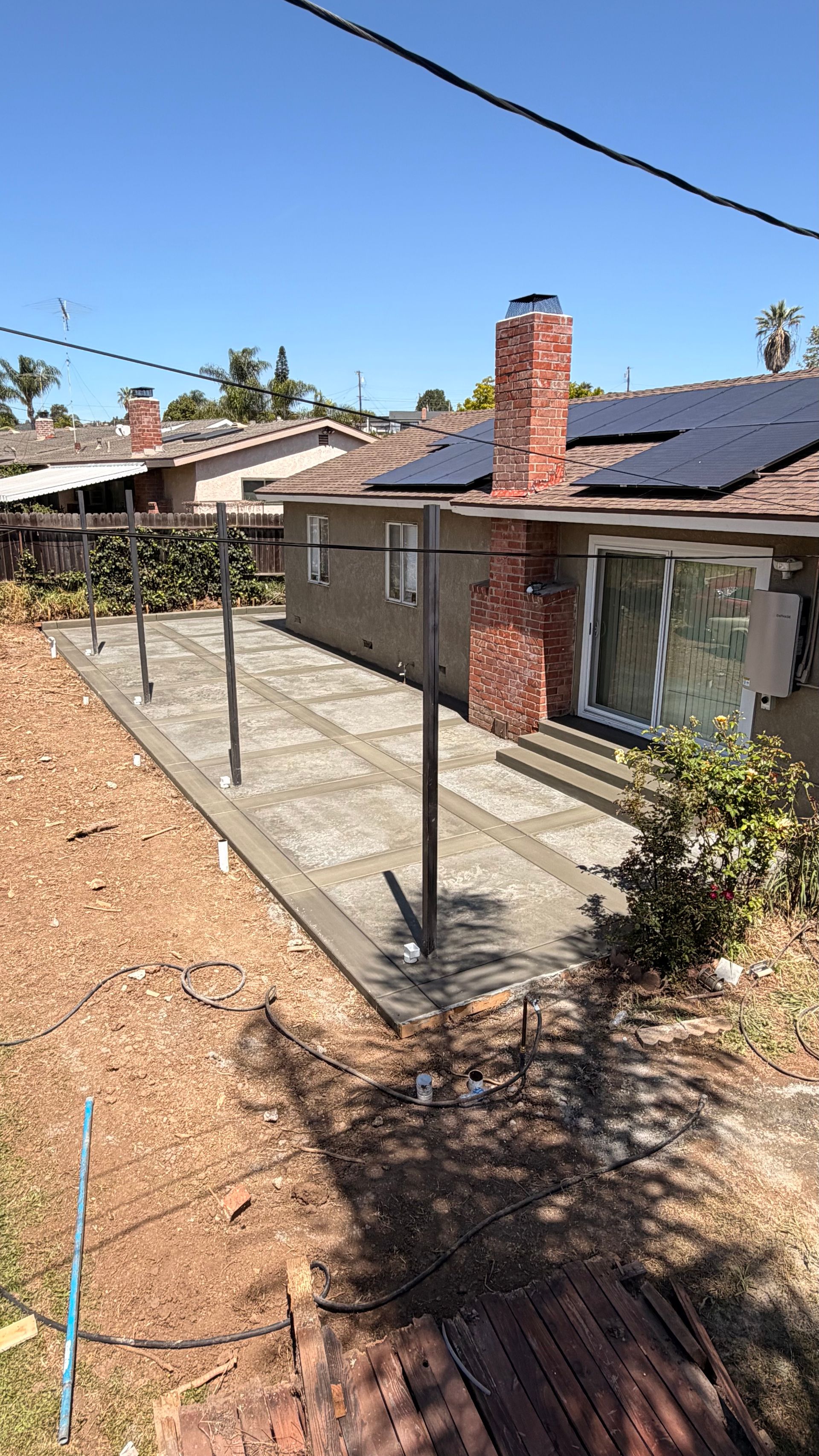 Backyard concrete patio with broom finish borders and Roman slate center in Jurupa Valley California