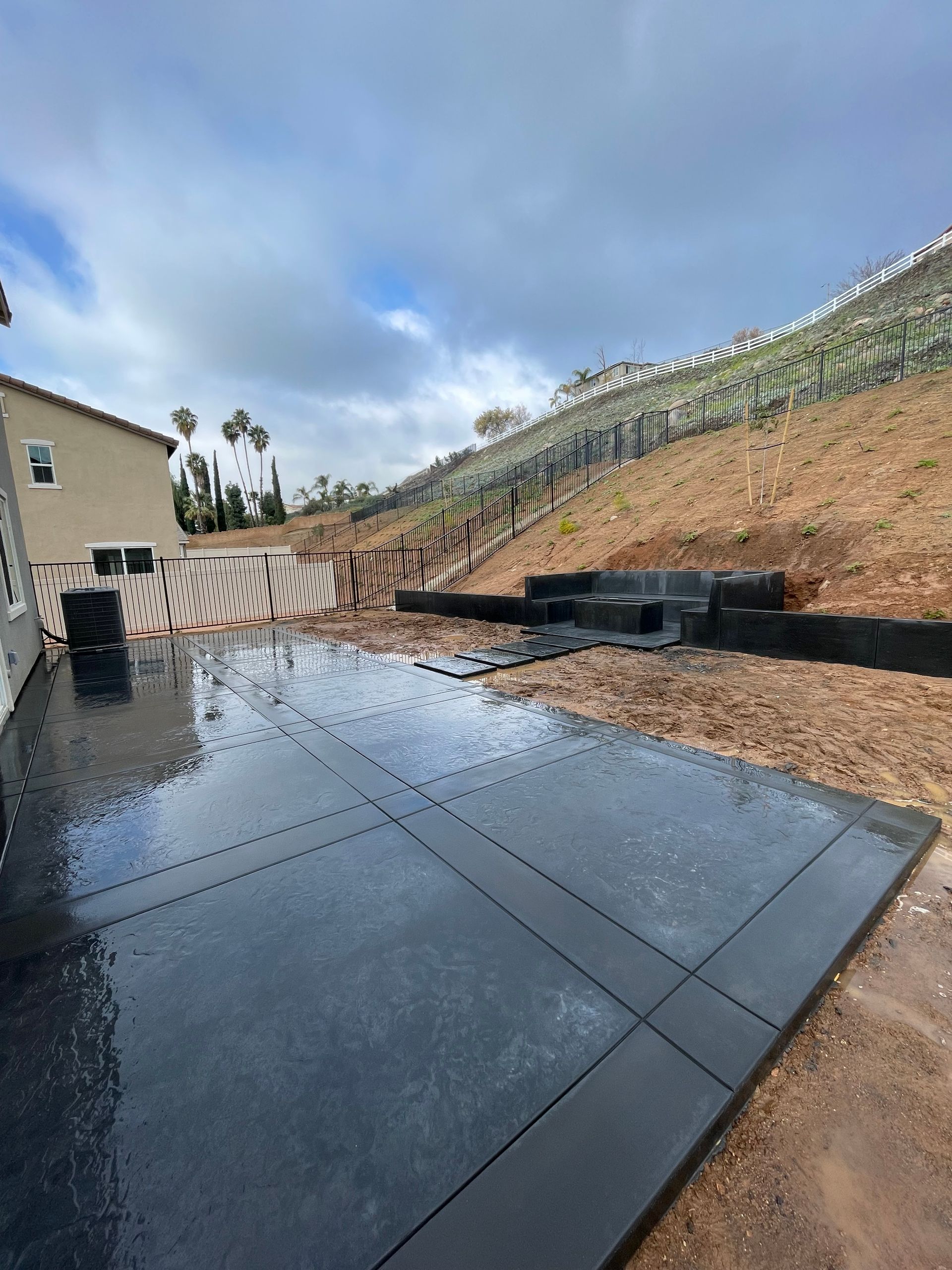 Colored concrete patio, fireplace, and bench installation in Highland California