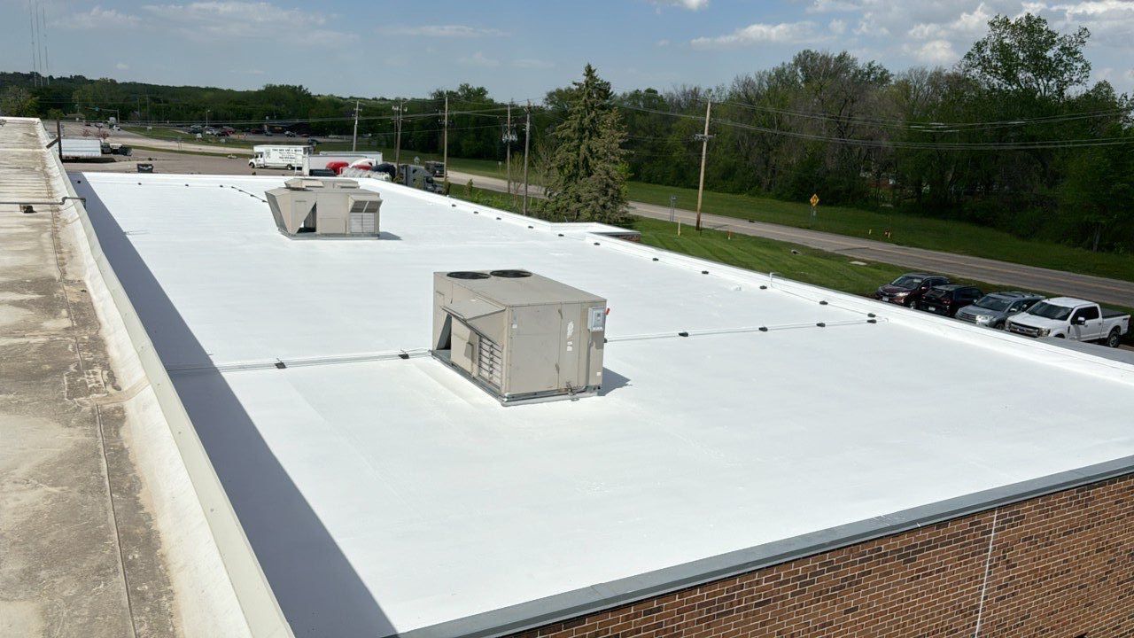 A large white roof with a lot of air conditioners on it.