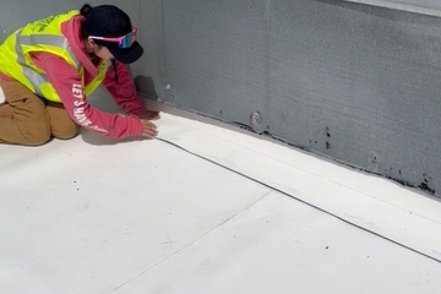 Roofing crew sealing seams on a commercial flat roof to prevent leaks in Wisconsin