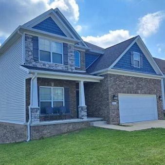 Two-story suburban brick and siding house with a front porch, garage, and green lawn