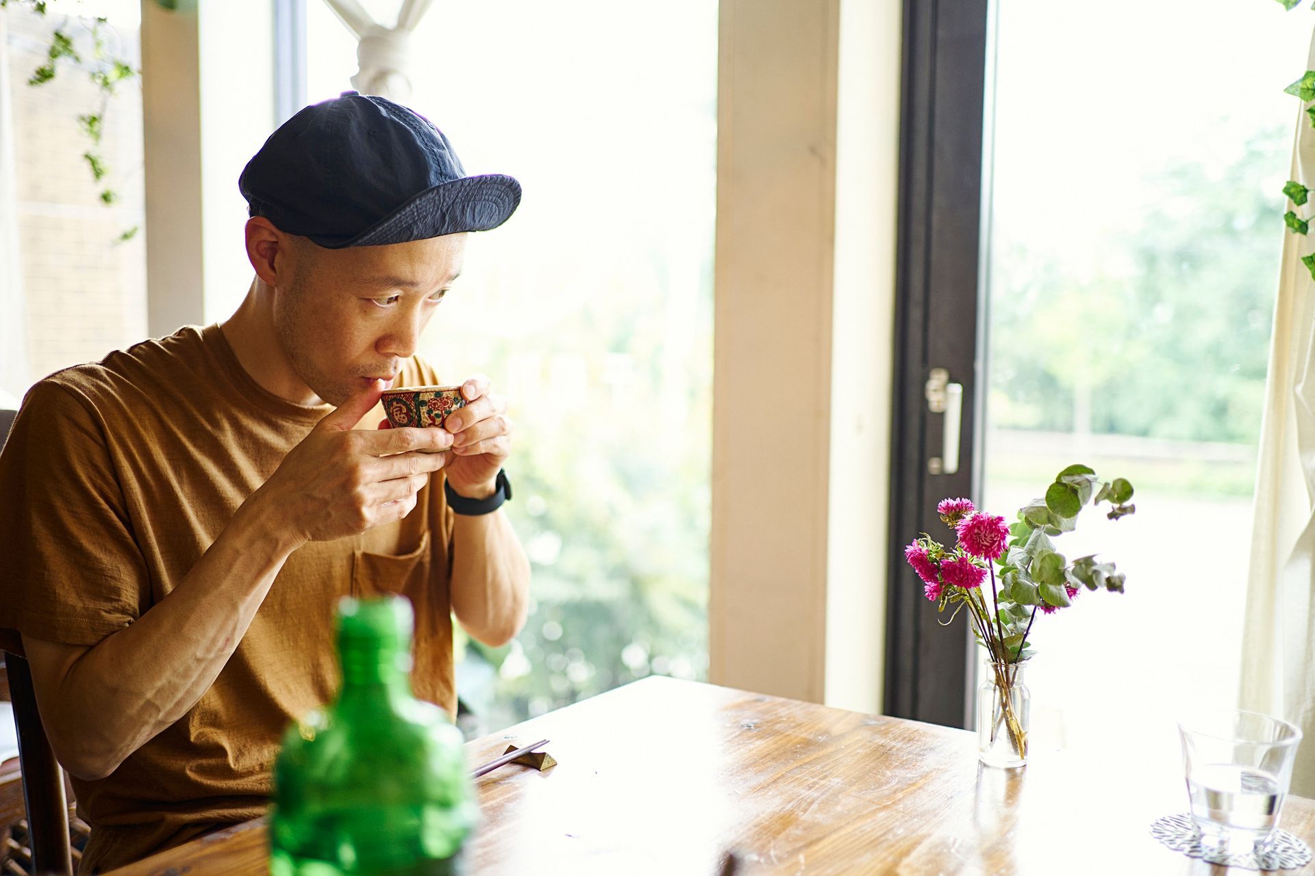 A man enjoys spending time at a tea house while drinking hot tea. A man enjoys spending time at a tea house while drinking hot tea.