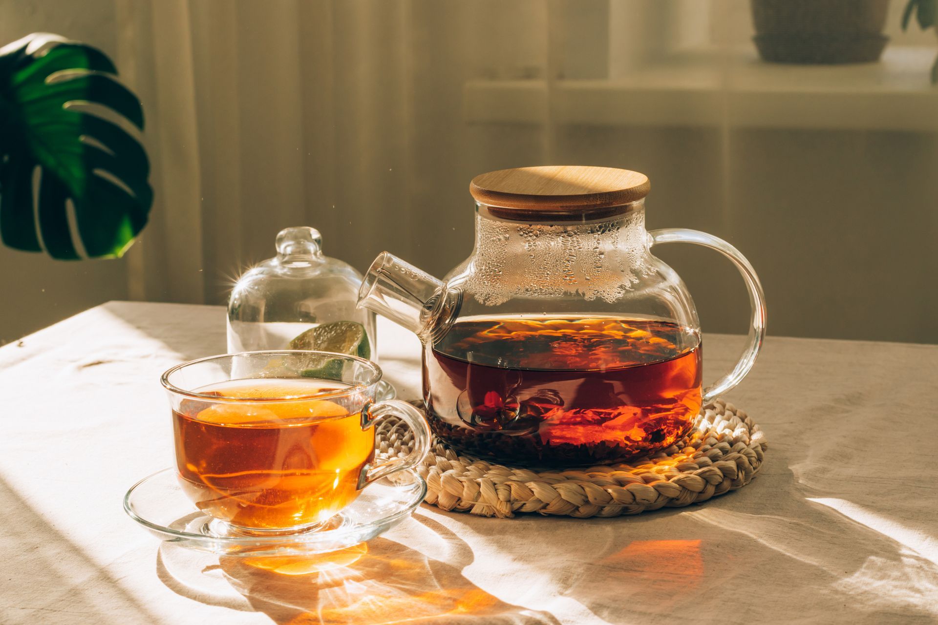 Hot tea or flower tea in a glass tea kettle surrounded by glass tea cups on a round wooden tray. Hot tea or flower tea in a glass tea kettle surrounded by glass tea cups on a round wooden tray.