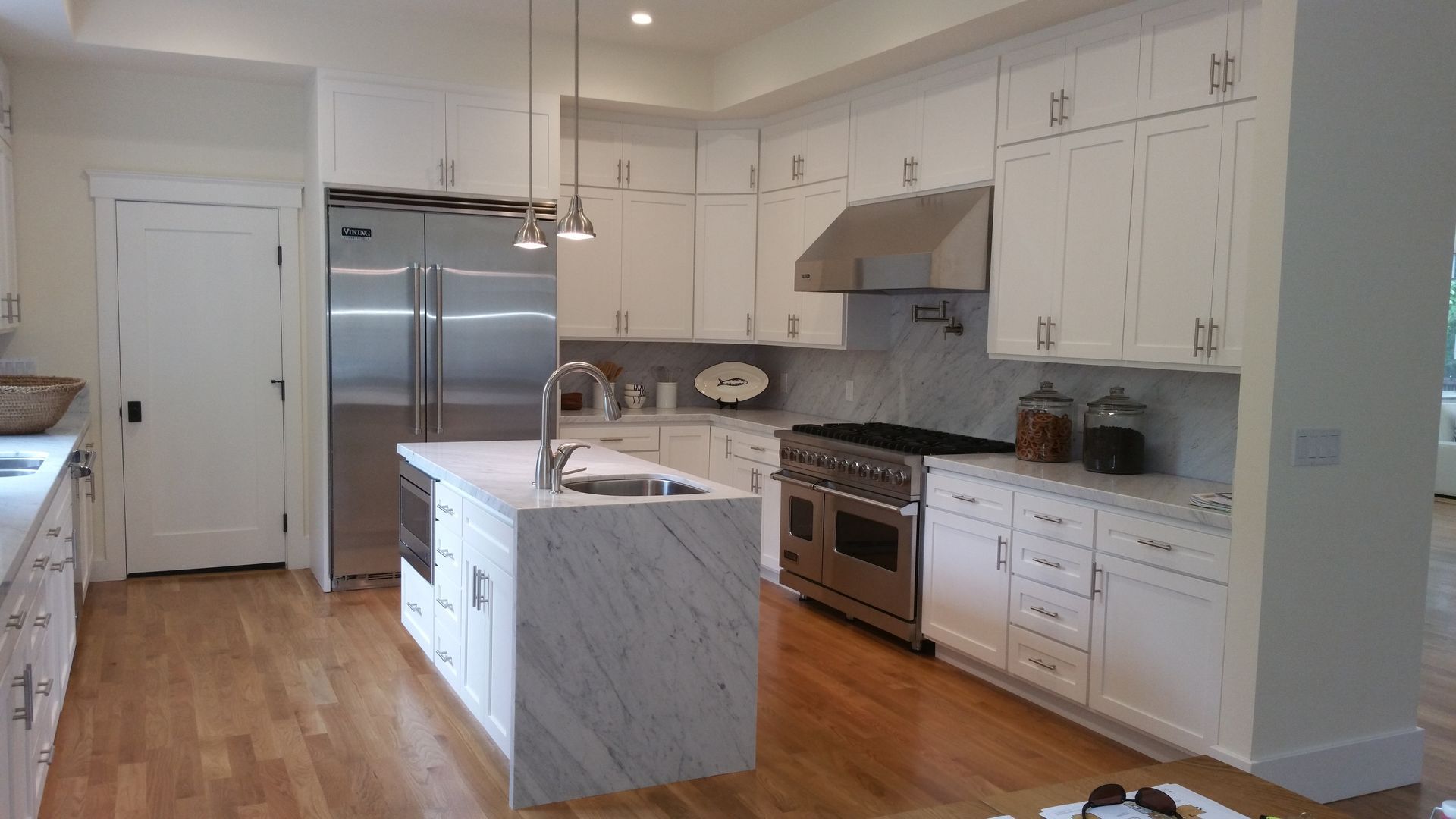 A kitchen with stainless steel appliances and white cabinets.