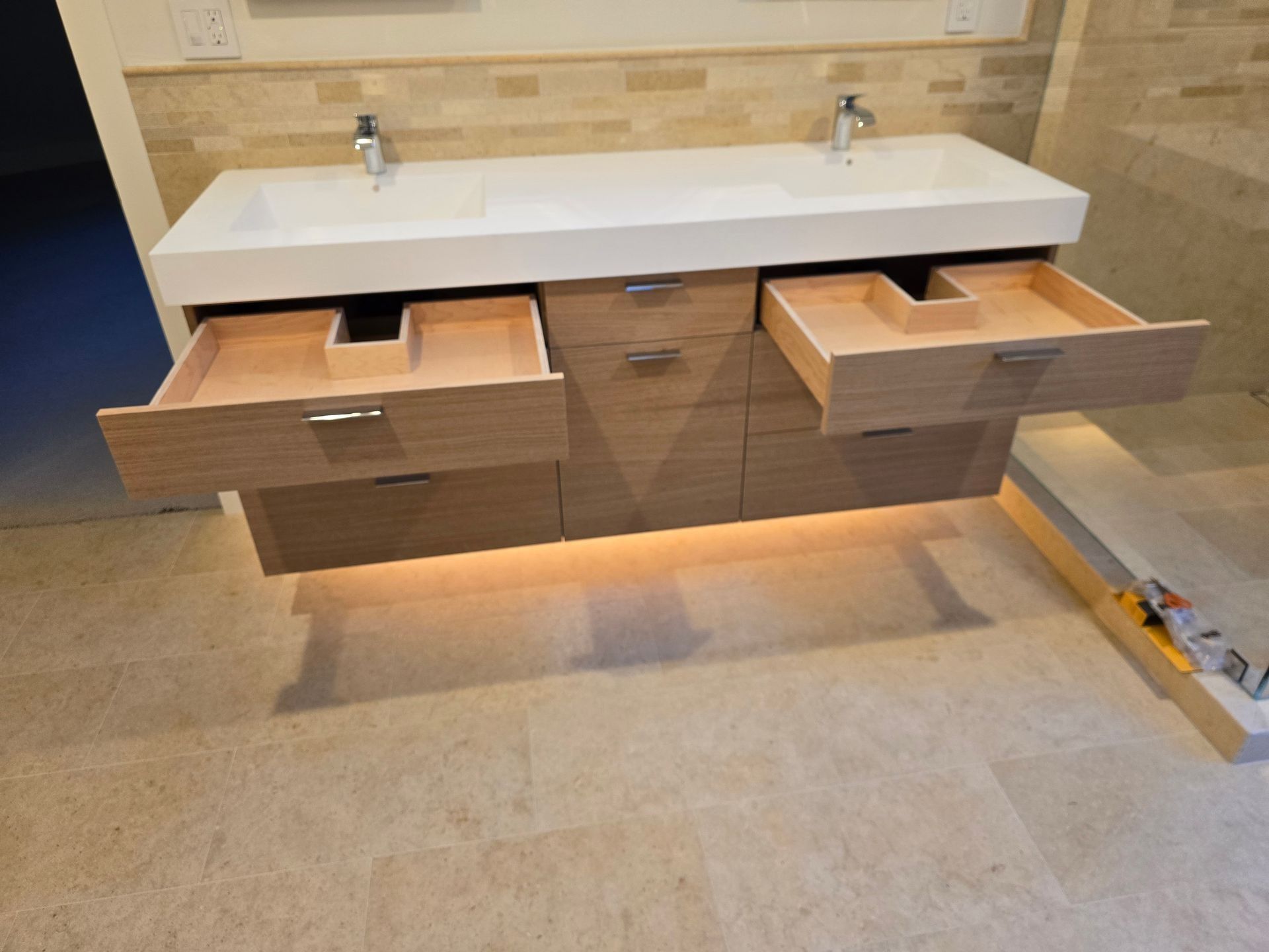A bathroom vanity with two sinks and drawers open.