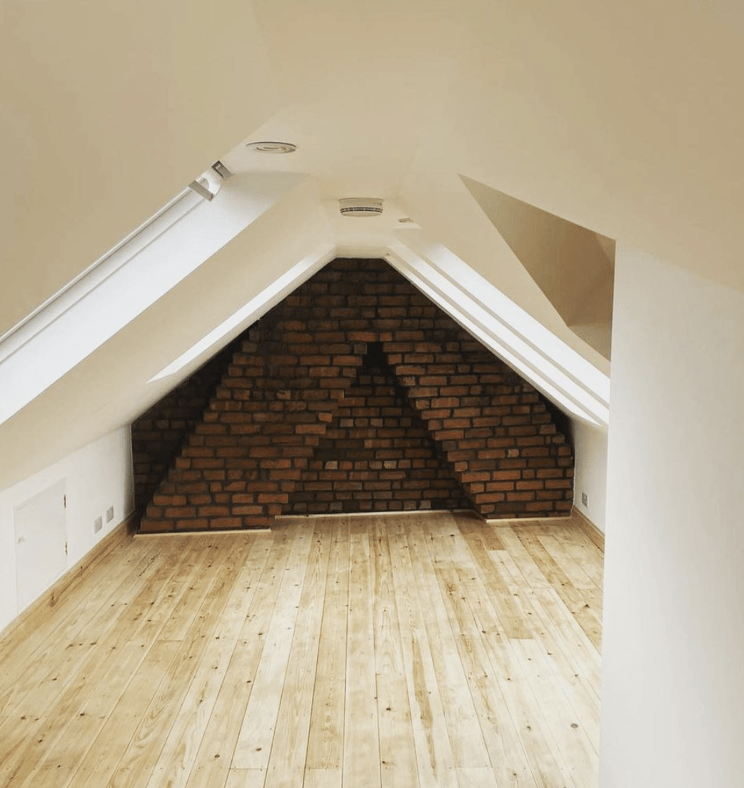Loft conversion with a brick wall and a wooden floor
