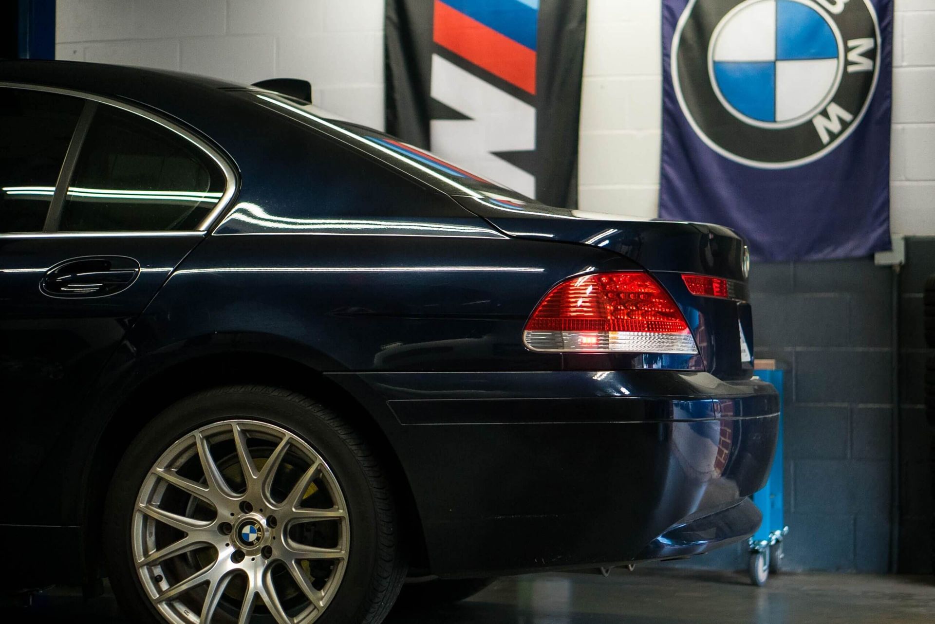 A bmw car is parked in a garage next to a bmw flag. | The Euro Shop