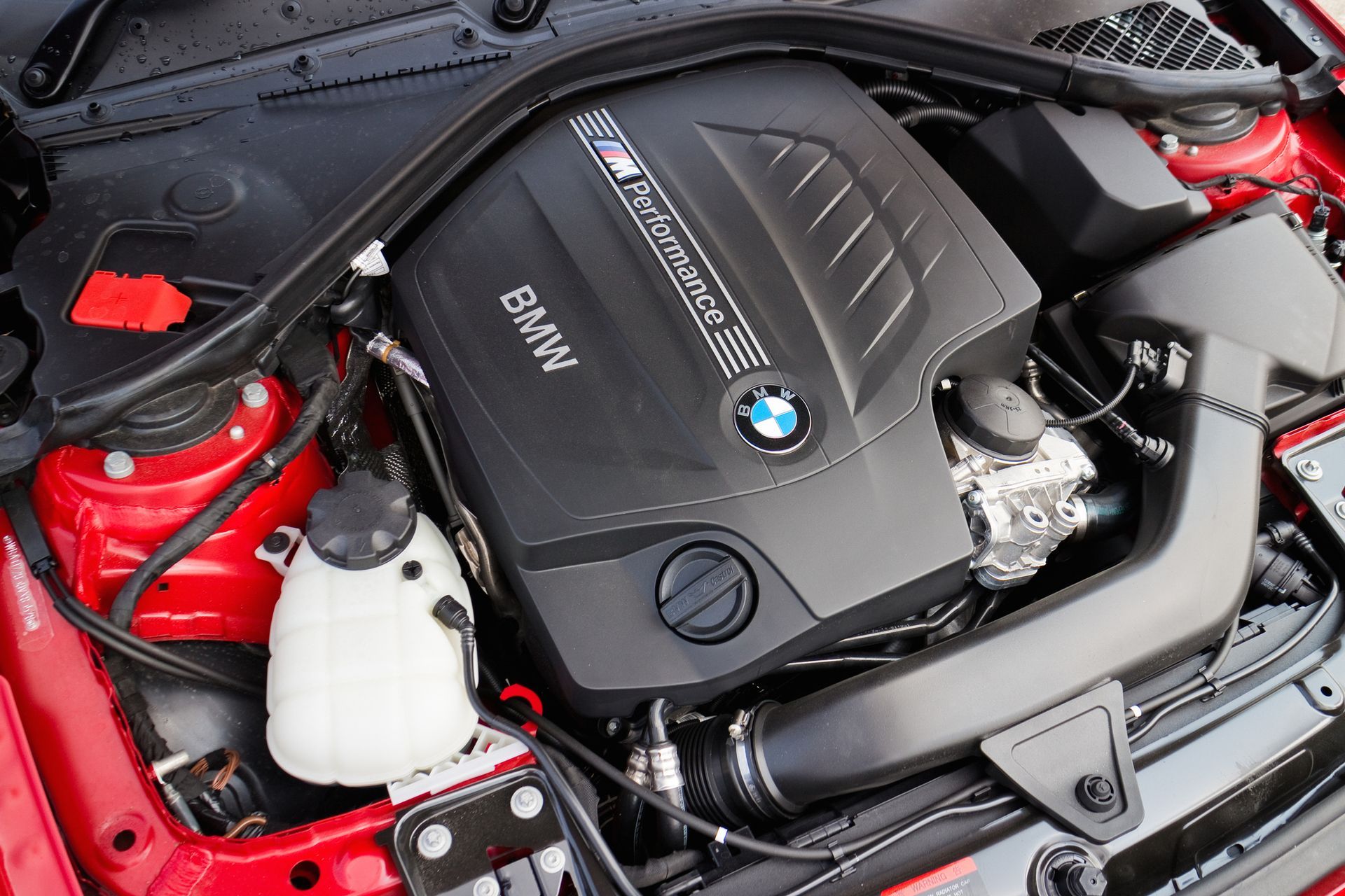 A close up of the engine of a red bmw | The Euro Shop