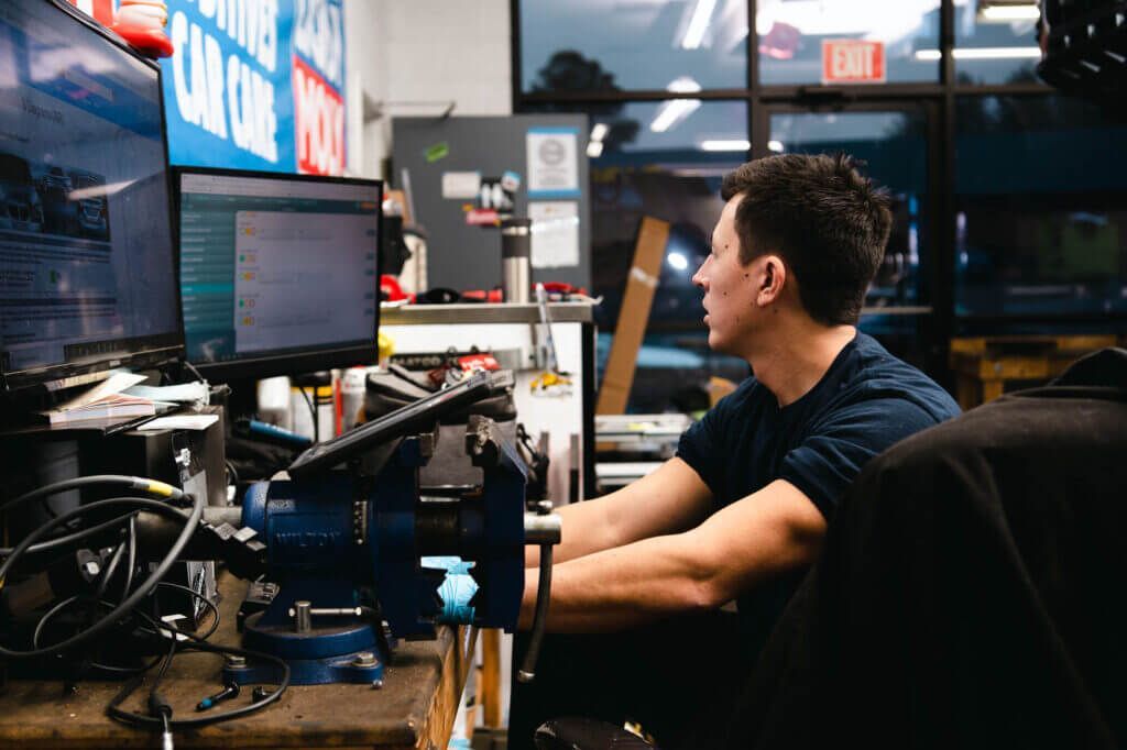 A man is sitting at a desk in front of a computer. | The Euro Shop